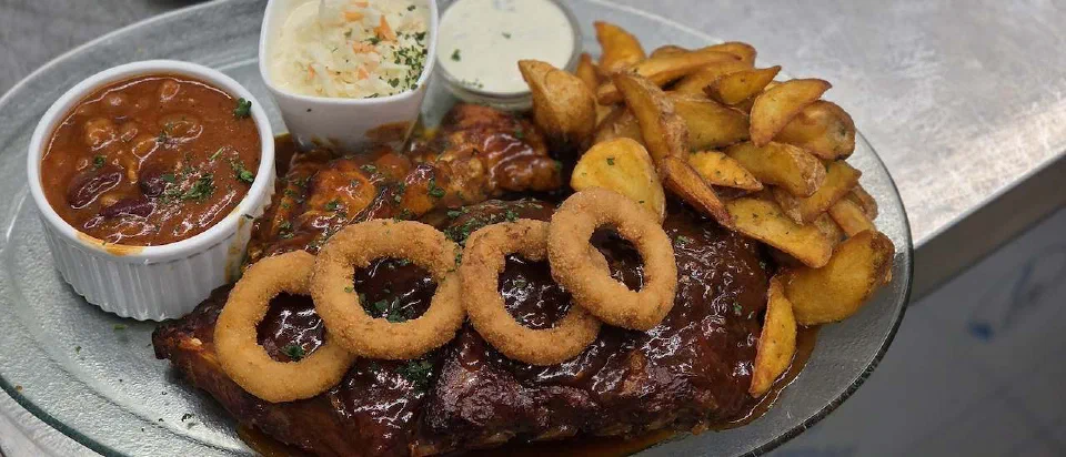 BBQ Combo mit Fleisch, Zwiebelringen, Kartoffelspalten und Dips